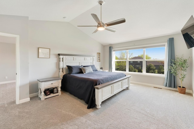 bedroom with light colored carpet, vaulted ceiling, baseboards, and ceiling fan