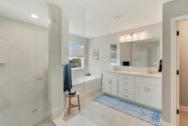 bathroom with a garden tub, a tile shower, tile patterned floors, and double vanity