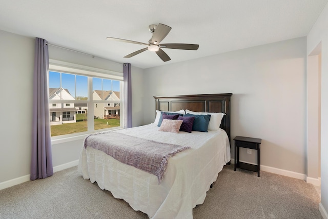 carpeted bedroom with baseboards and a ceiling fan