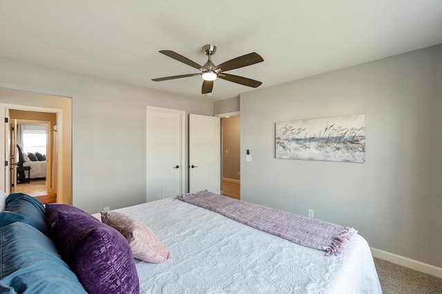 bedroom featuring baseboards, light colored carpet, and ceiling fan