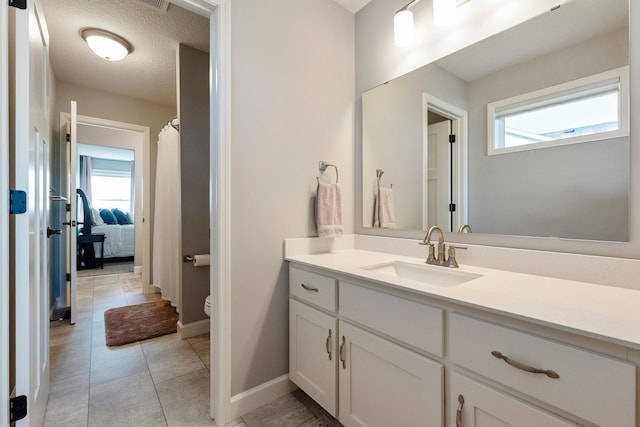 full bath featuring toilet, plenty of natural light, vanity, and baseboards