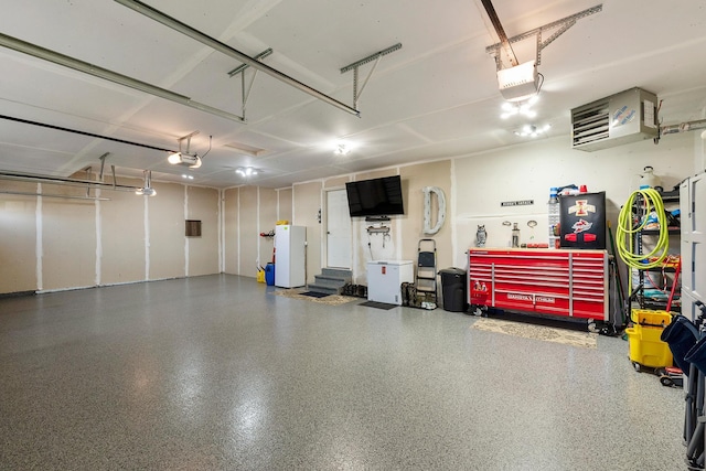 garage featuring a garage door opener and a workshop area