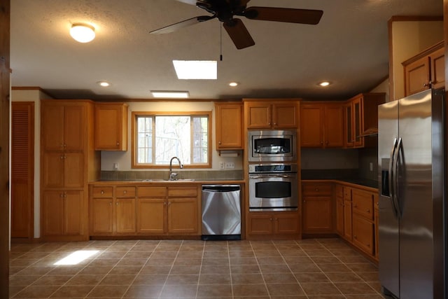 kitchen with appliances with stainless steel finishes, a sink, ceiling fan, recessed lighting, and tile patterned flooring