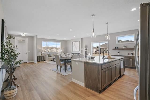 1234 Willowbrook Cir, Delano, MN 55328 - kitchen with light wood finished floors, dark brown cabinets, a sink, a wealth of natural light, and appliances with stainless steel finishes