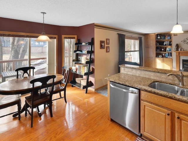 2052 Wilhelm Ct, Shakopee, MN 55379 - kitchen featuring dishwasher, a sink, light wood-style floors, decorative light fixtures, and light stone counters