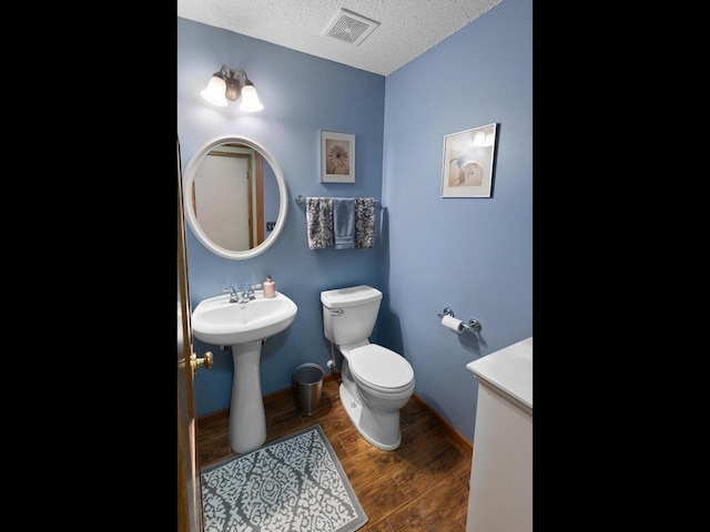 2052 Wilhelm Ct, Shakopee, MN 55379 - half bathroom with a textured ceiling, toilet, and wood finished floors