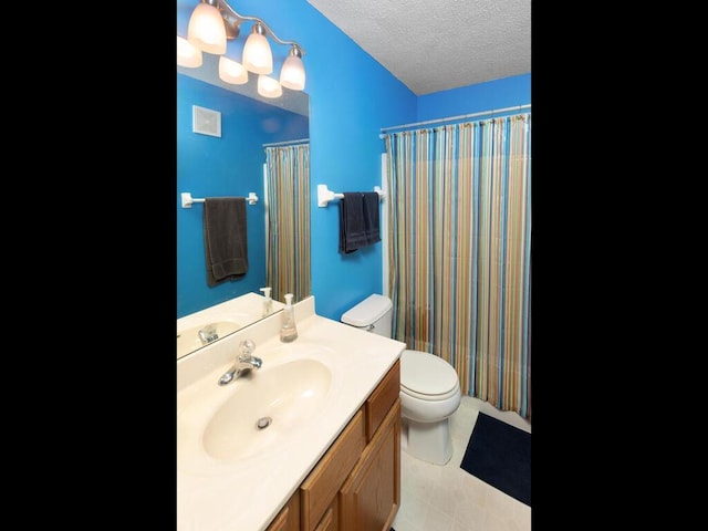 2052 Wilhelm Ct, Shakopee, MN 55379 - bathroom featuring toilet, vanity, a textured ceiling, a shower with shower curtain, and tile patterned floors