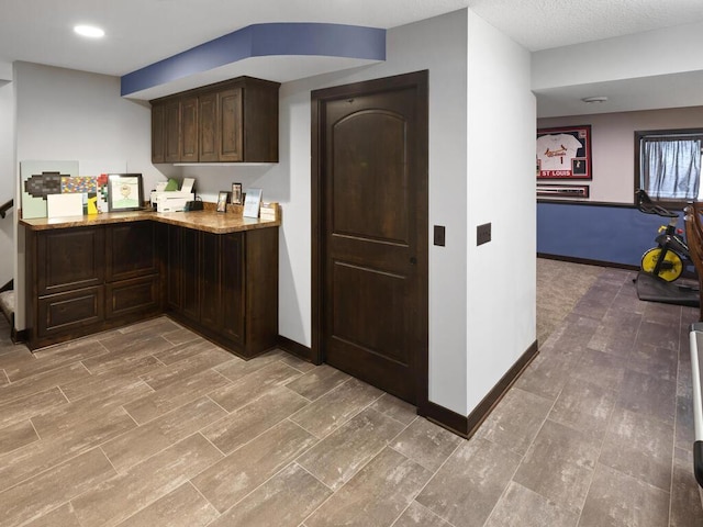 2052 Wilhelm Ct, Shakopee, MN 55379 - kitchen with dark brown cabinetry, baseboards, recessed lighting, and light stone counters
