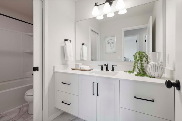 full bathroom with toilet, a bathtub, vanity, and marble finish floor