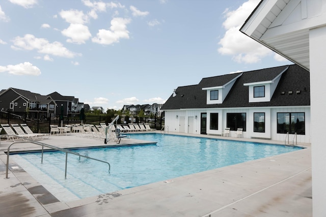 pool with a residential view, a patio area, and fence