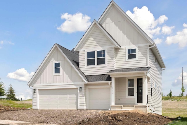 view of front of home featuring a garage, board and batten siding, driveway, and roof with shingles