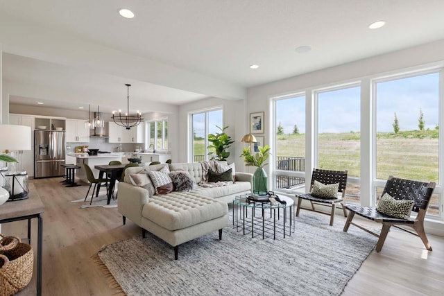 living area featuring light wood-type flooring, an inviting chandelier, and recessed lighting