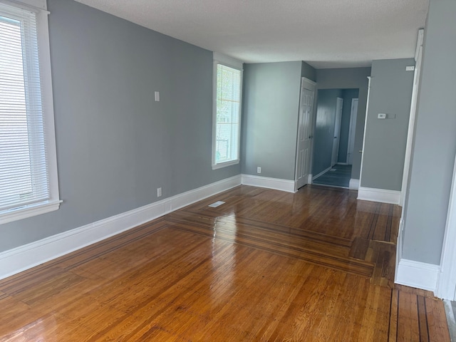 empty room with baseboards and hardwood / wood-style floors