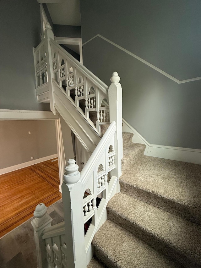 stairway with baseboards and wood finished floors
