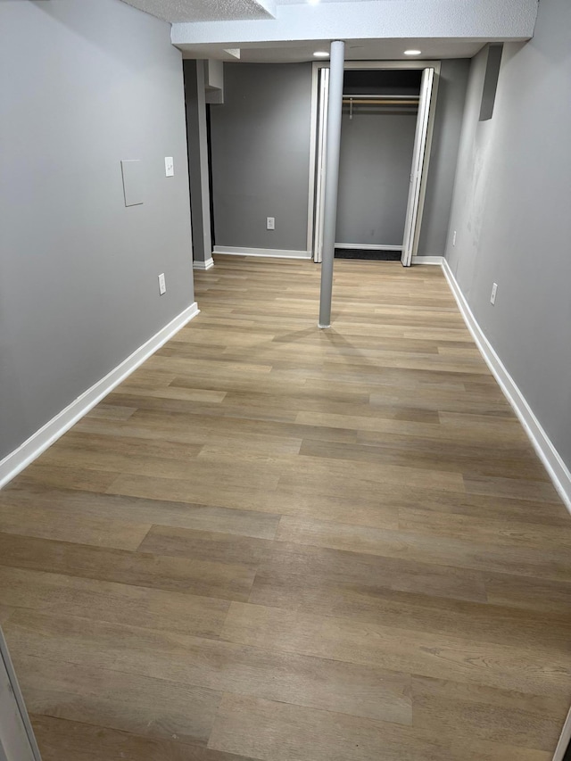 unfurnished bedroom with baseboards, light wood-type flooring, and a closet