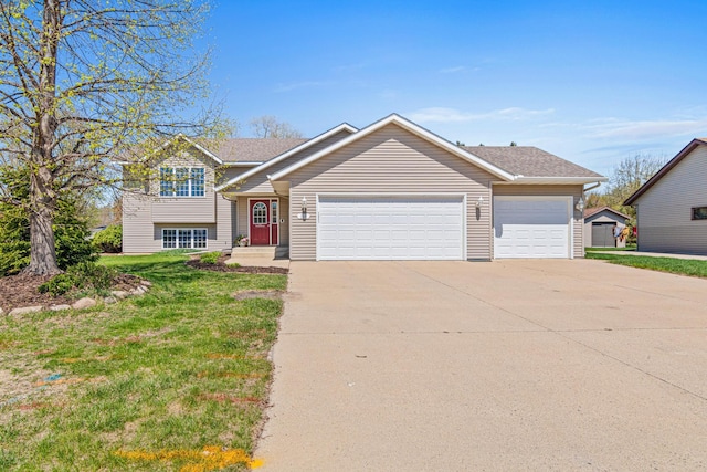 tri-level home with a garage, driveway, and a front yard