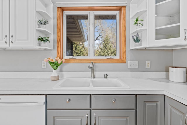 kitchen featuring dishwasher, open shelves, a sink, and gray cabinetry