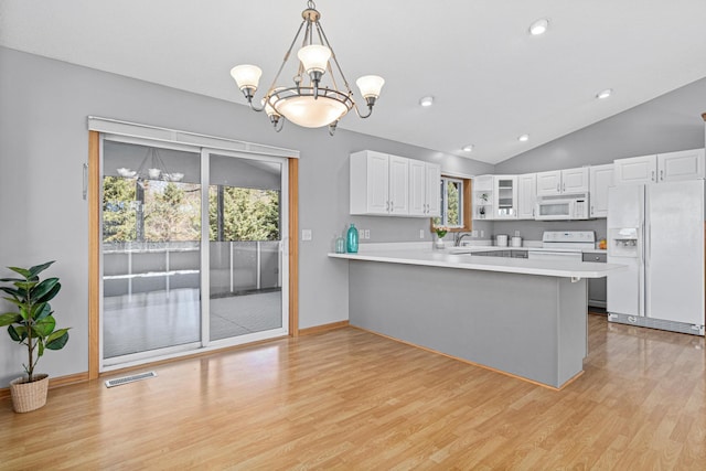 kitchen featuring white appliances, light wood-type flooring, white cabinets, light countertops, and a peninsula