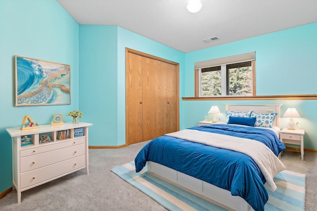 carpeted bedroom with baseboards and a closet