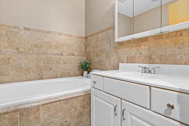 bathroom with tile walls, a bath, and vanity
