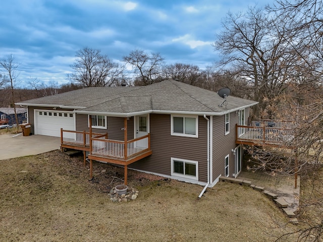 back of property featuring a yard, driveway, a shingled roof, and a garage