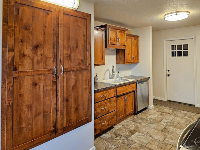 kitchen featuring brown cabinets, dark countertops, a sink, tasteful backsplash, and stainless steel dishwasher