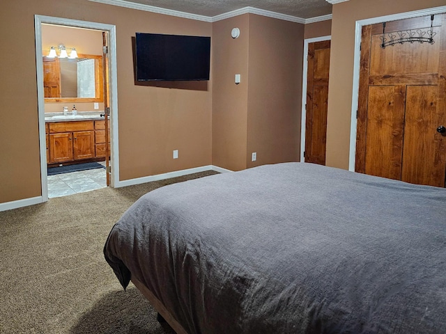 bedroom with crown molding, a sink, baseboards, ensuite bathroom, and light carpet