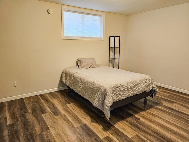 bedroom featuring baseboards and wood finished floors