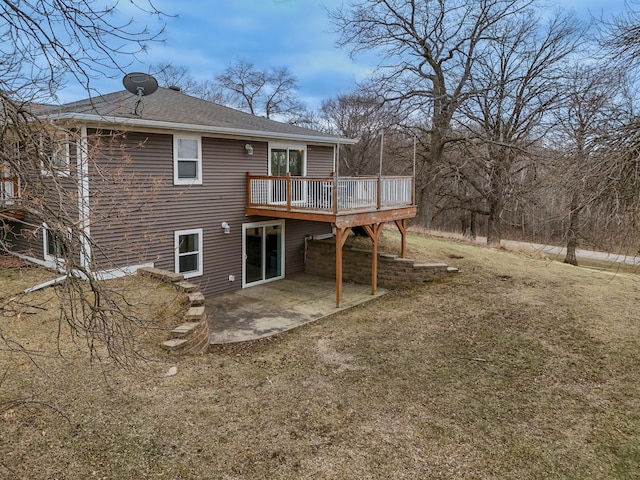 rear view of property featuring roof with shingles, a yard, a patio area, and a deck