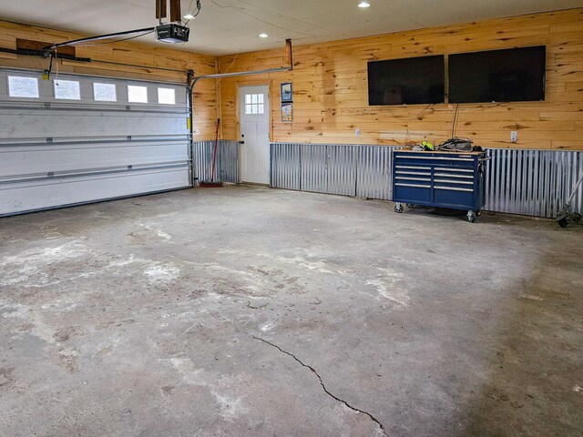 garage featuring recessed lighting, wood walls, and a garage door opener