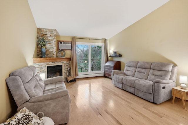3850 Plymouth Blvd Unit 318, Plymouth, MN 55446 - living room with a stone fireplace, a wall mounted AC, vaulted ceiling, a baseboard radiator, and light wood-style flooring