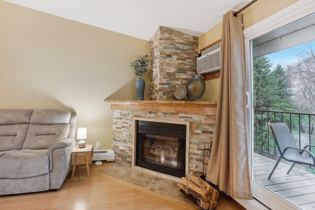 3850 Plymouth Blvd Unit 318, Plymouth, MN 55446 - living area featuring baseboard heating, a stone fireplace, a wall unit AC, and wood finished floors