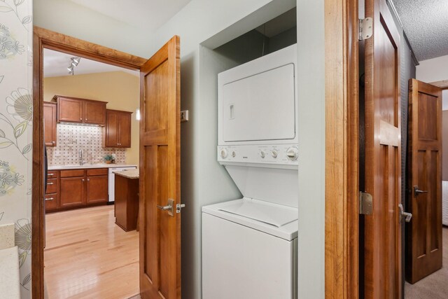3850 Plymouth Blvd Unit 318, Plymouth, MN 55446 - clothes washing area featuring stacked washer and dryer, laundry area, and light wood-style floors