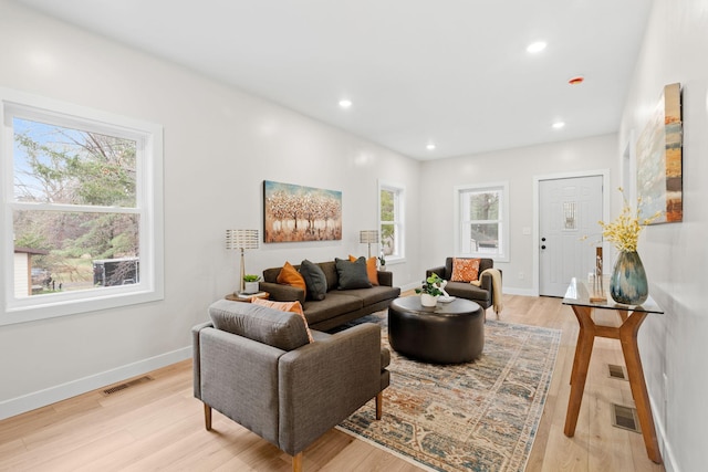 living area featuring light wood-style flooring, baseboards, and recessed lighting