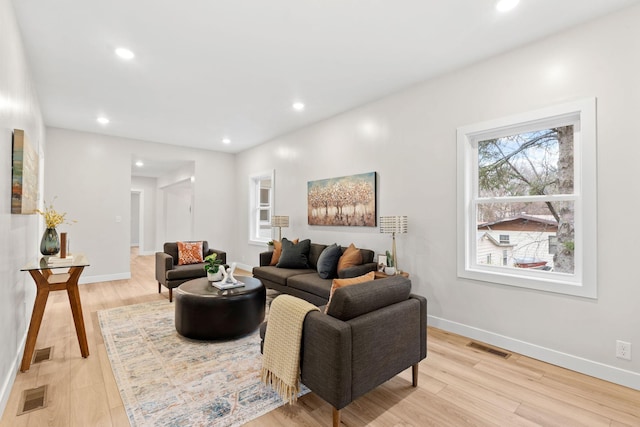 living area featuring baseboards, light wood-style floors, and recessed lighting