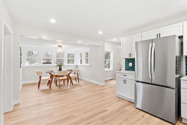 kitchen featuring freestanding refrigerator, baseboards, light wood-style floors, white cabinets, and recessed lighting