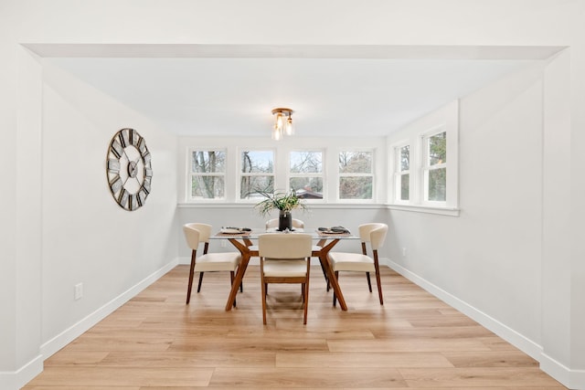 dining room with healthy amount of natural light, light wood-style floors, and baseboards