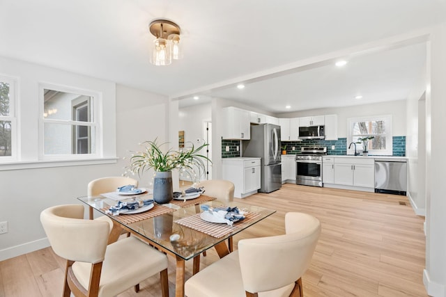 dining room featuring light wood finished floors, baseboards, and recessed lighting