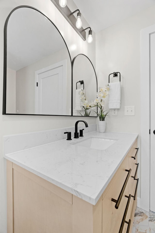 bathroom featuring marble finish flooring and vanity