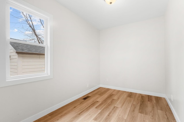 spare room with wood finished floors and baseboards