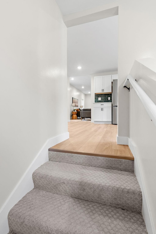 stairs with baseboards, recessed lighting, and wood finished floors