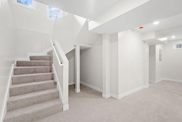 basement with carpet floors, stairway, baseboards, plenty of natural light, and recessed lighting
