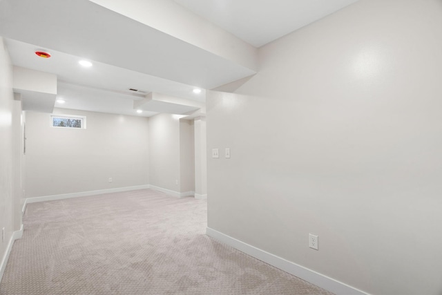 below grade area featuring light colored carpet, baseboards, and recessed lighting