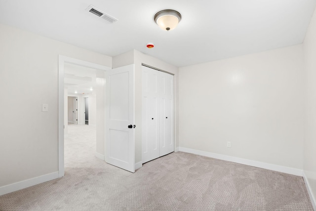 unfurnished bedroom featuring light colored carpet, baseboards, and a closet
