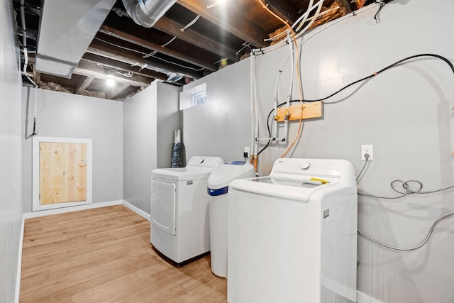 washroom with independent washer and dryer, light wood-type flooring, and baseboards
