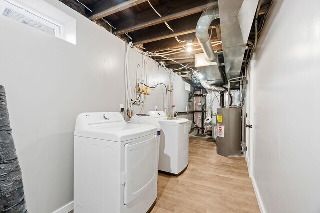 laundry room featuring electric water heater, washer and dryer, and light wood finished floors