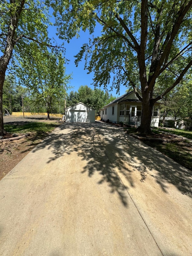 view of front facade with driveway, a garage, and an outdoor structure
