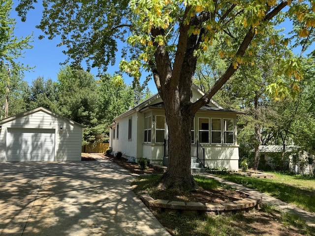 view of side of home featuring a garage, an outbuilding, and fence