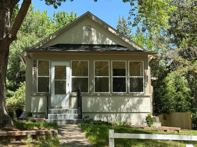 view of home's exterior with entry steps, fence, and stucco siding