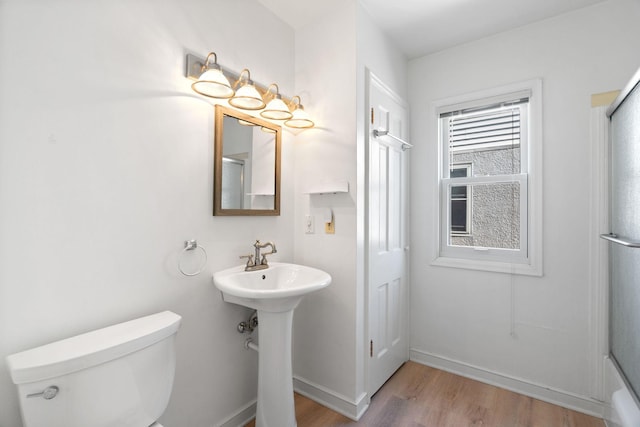 full bathroom with baseboards, an enclosed shower, wood finished floors, and toilet
